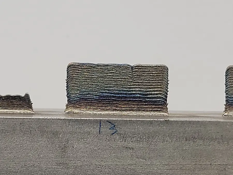 As-built LPDED wall — cracked. Laser powder direct energy deposition of a Ni superalloy; the process window shows itself in the cracks.